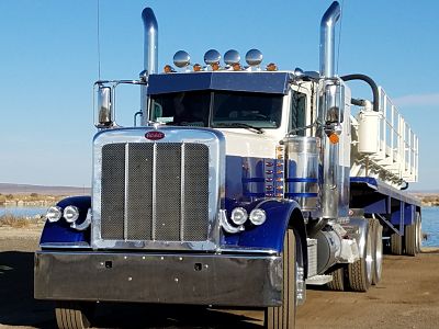 A blue and white truck is parked on the road.